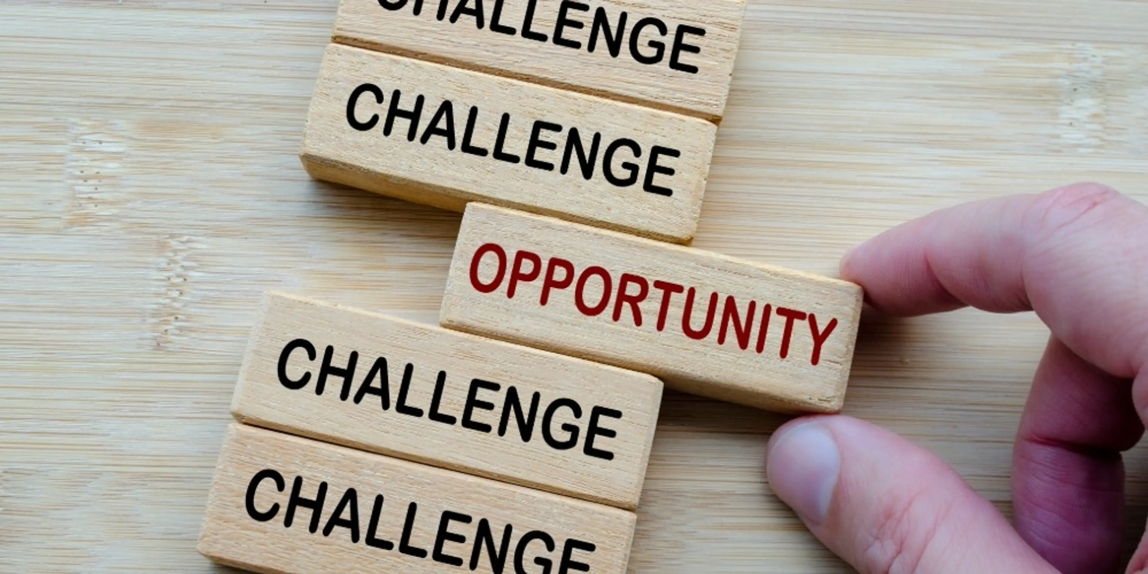 Challenges and Opportunities Coexist, a reminder that every challenge carries potential opportunities, shown through opposing wooden block messages