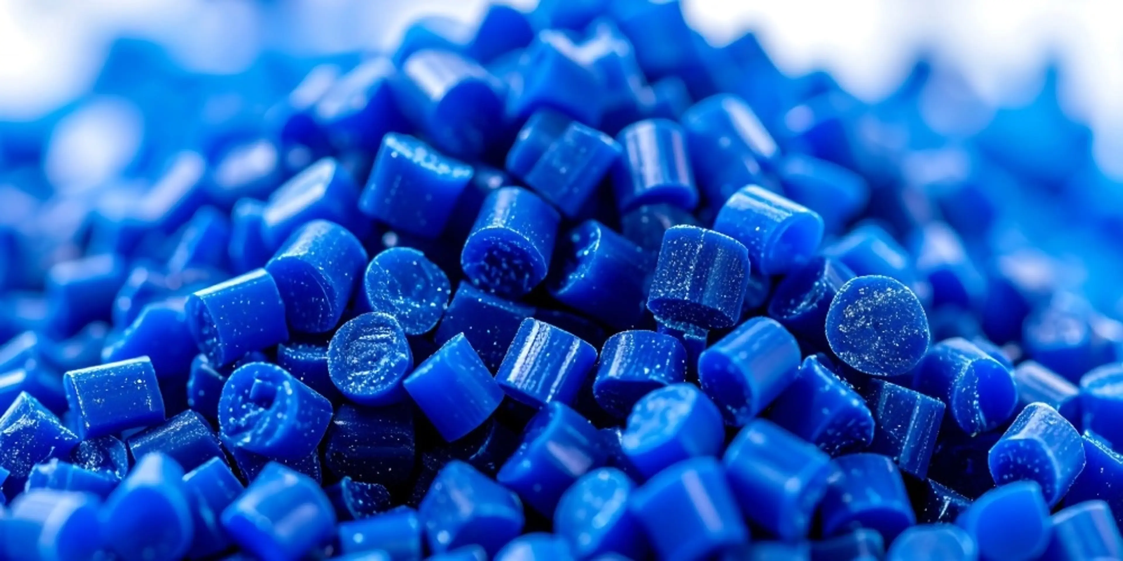 Close-up view of vibrant blue plastic polymer pellets, ideal for manufacturing and industrial applications.