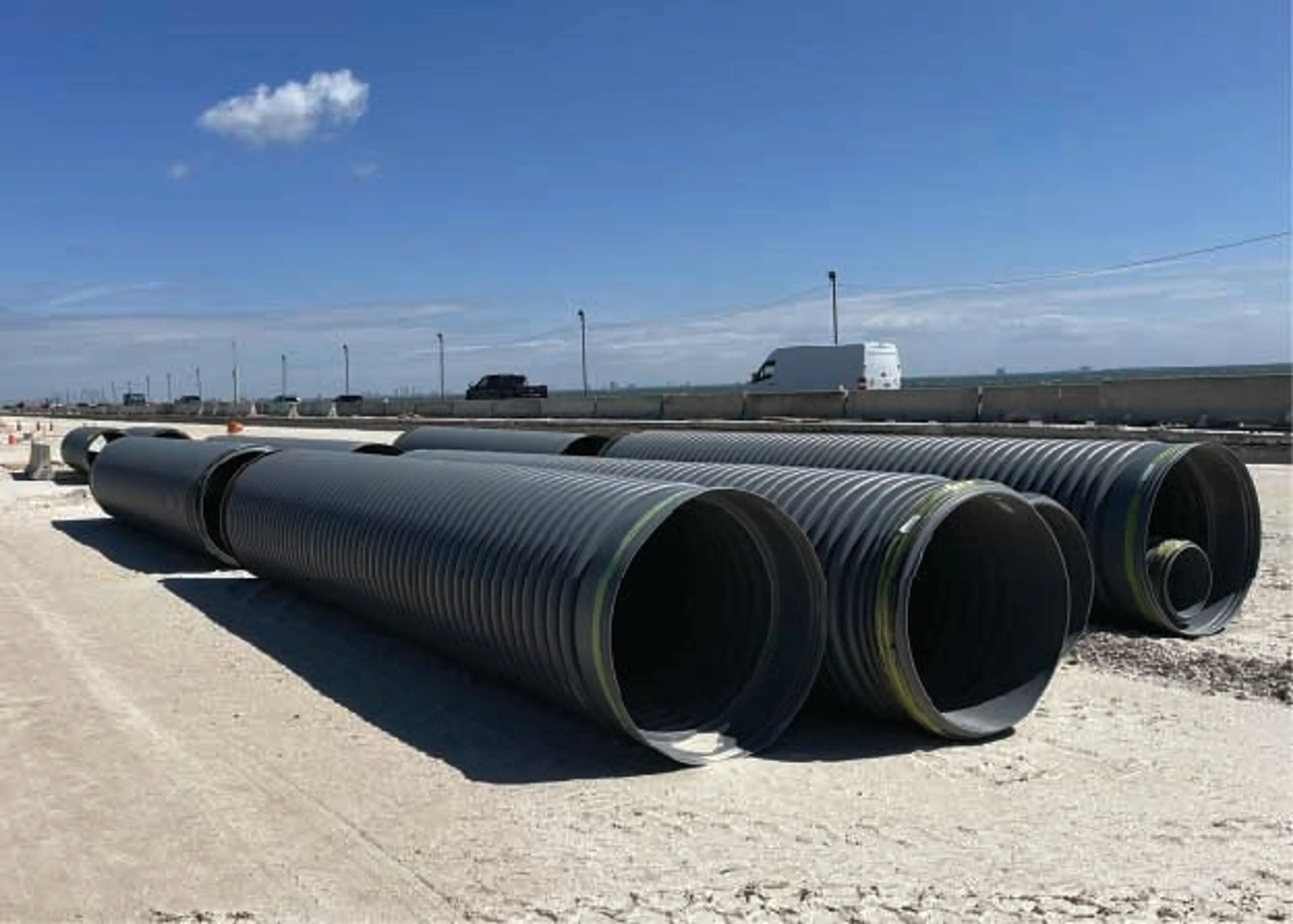 Large diameter blank plastic pipe with blue sky background on concrete ground
