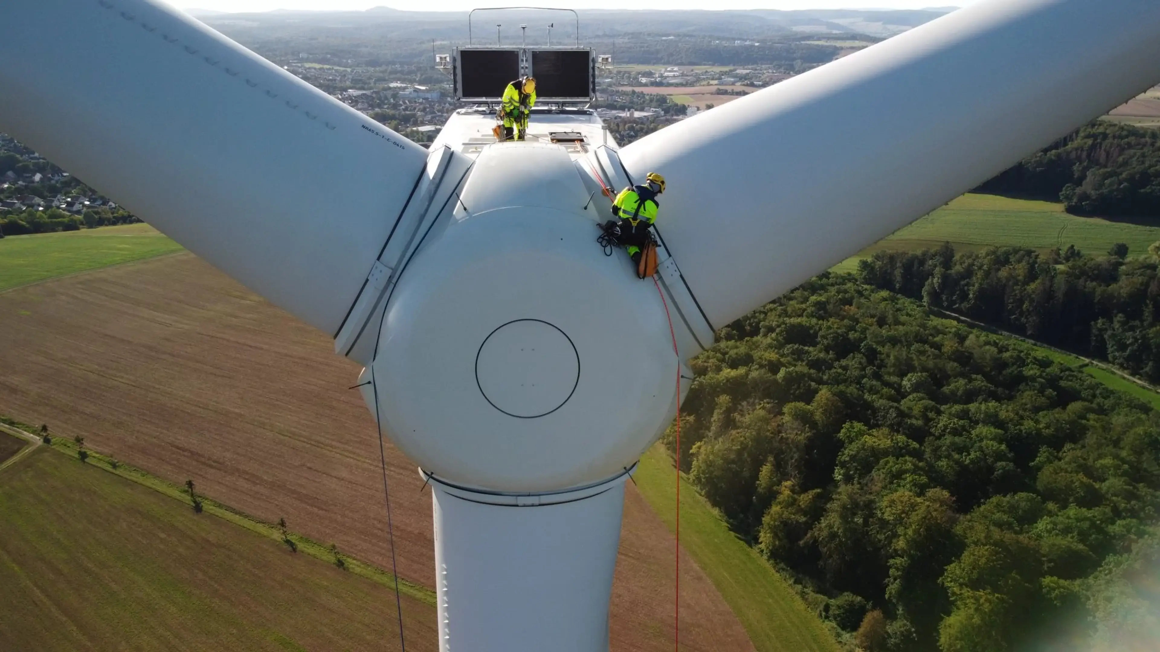 Photo of men working on a wind turbine blade