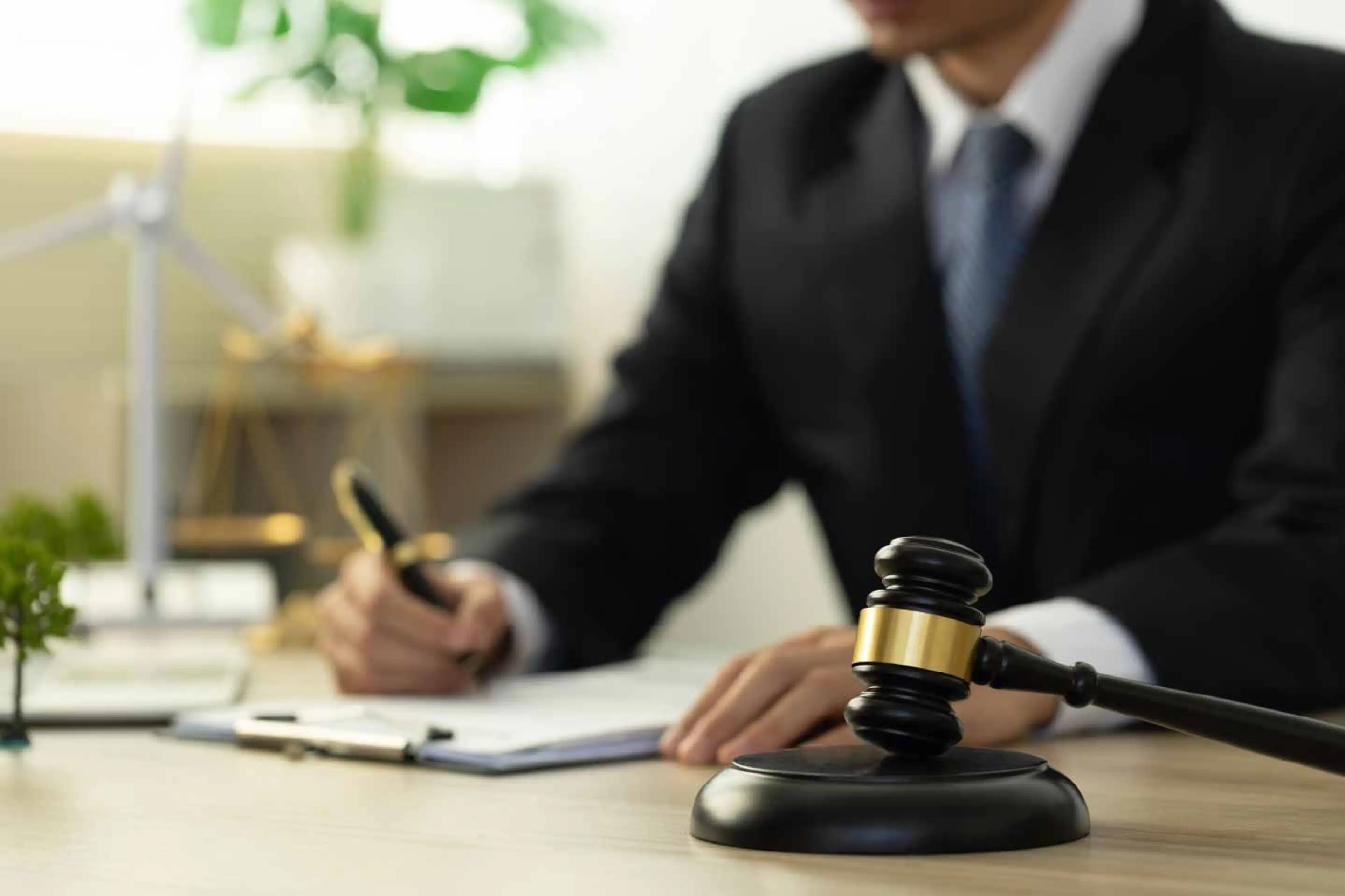 A judge's gavel resting on a wooden bench in a courtroom, symbolizing policy and regulation