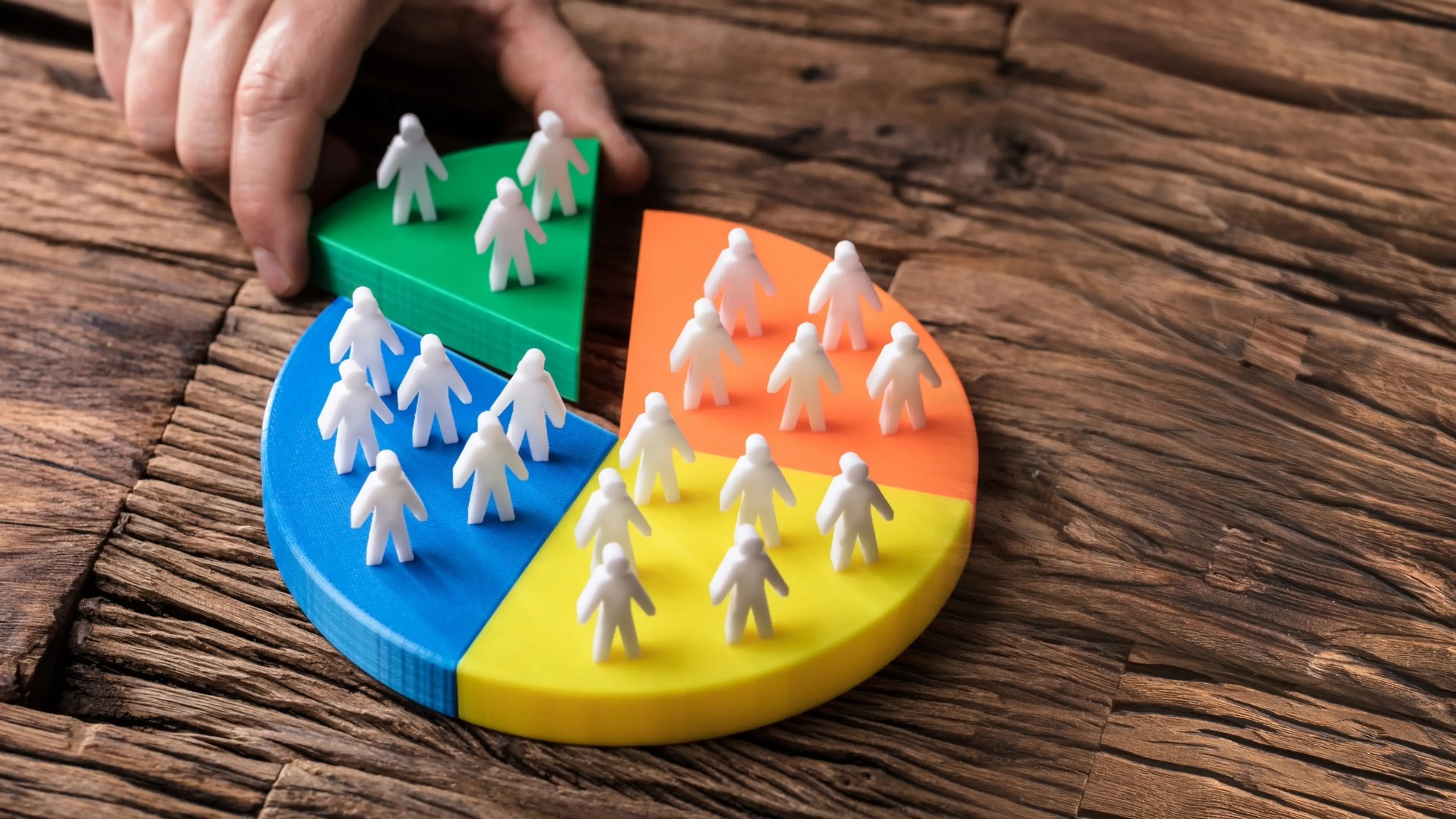 A person displays a pie chart with sections representing various individuals, highlighting demographic distribution.